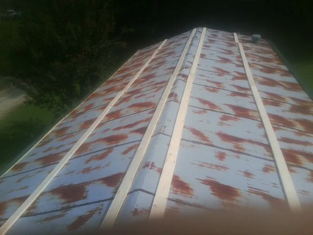 Rusted metal roof panels with new wood purlins before replacement — Storm Damage Roof Repair in Delcambre by Roofing Brothers