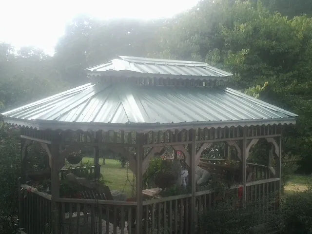 Two tier green metal roof on a garden gazebo in Delcambre