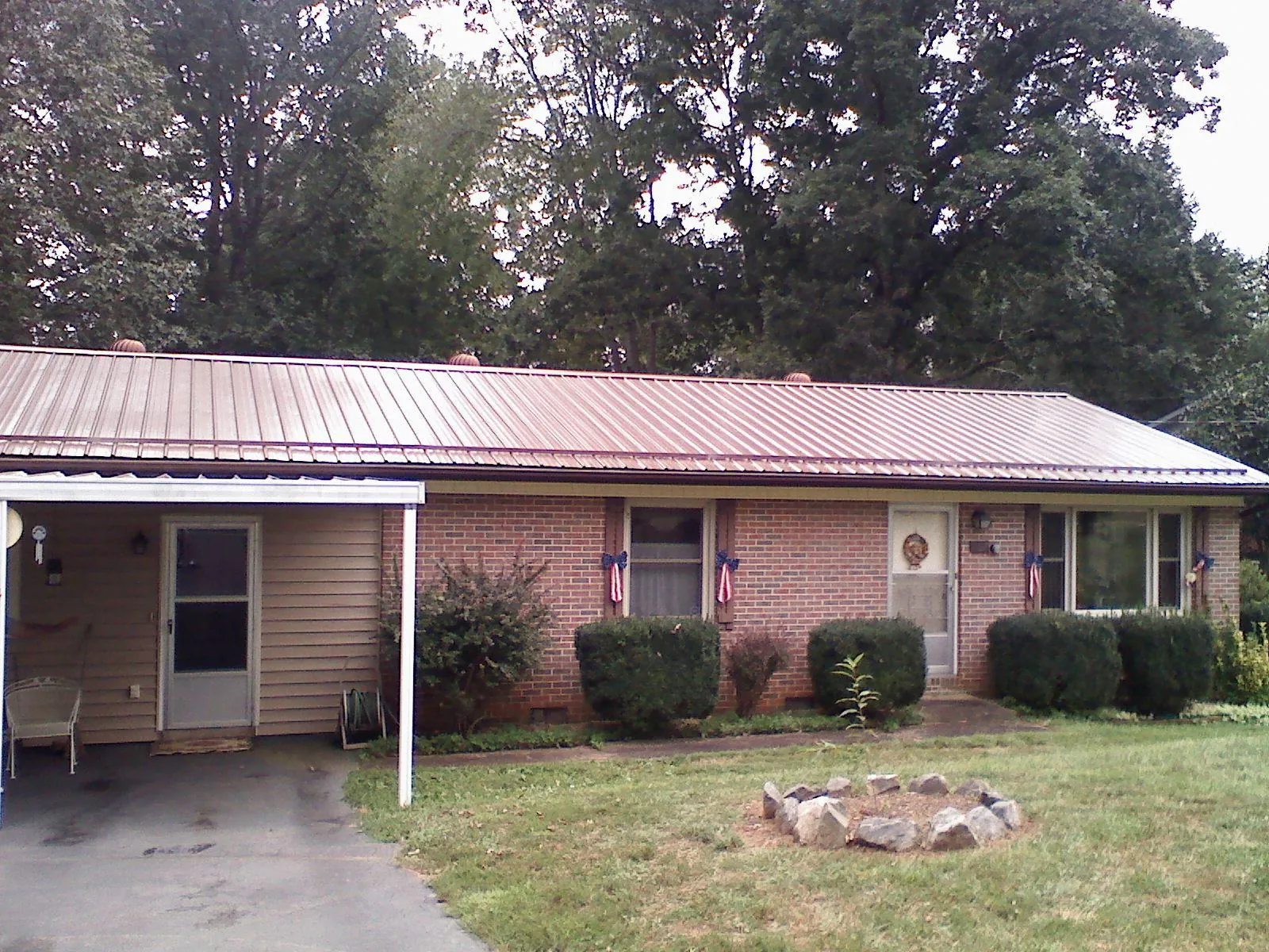 Bronze metal roof and carport on a brick ranch home — Roof Repair work by our crew in Delcambre